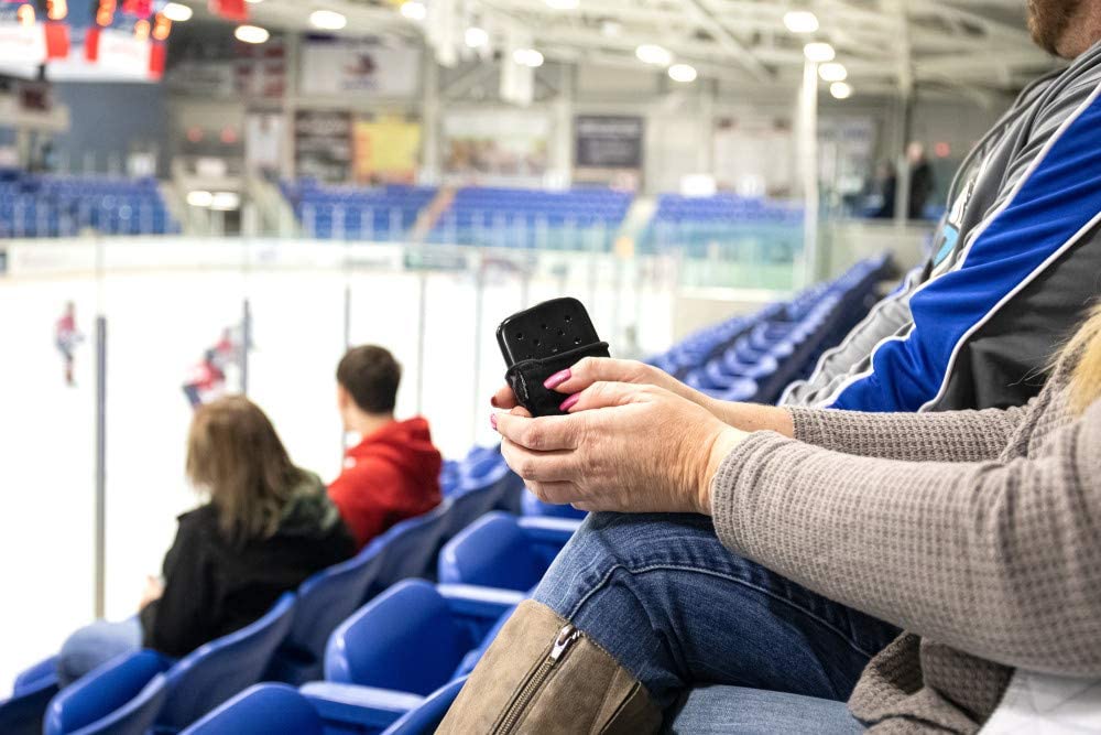 Black Zippo Refillable Hand Warmer Being Used by a woman inside a hockey rink
