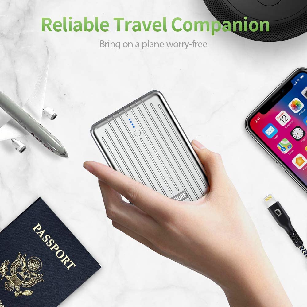 Zendure A3PD External Battery in hand with model plane, passport and cellphone