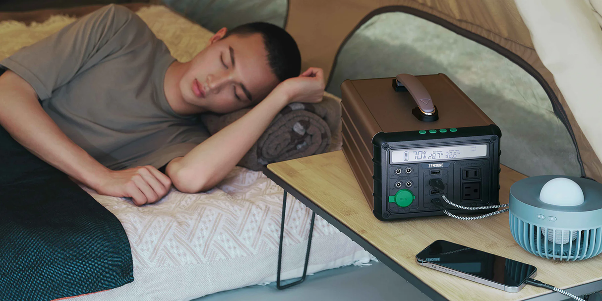 Zendure SuperBase M 1000 Watt  Portable Power Station in use in a tent with a young man sleeping