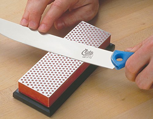 A person using two hands to sharpen a Cuda 500 knife on a DMT Diamond Sharpener Block.