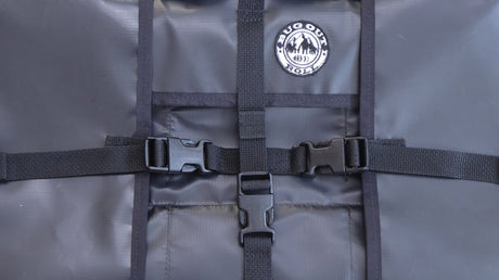 The teramaster material of the Bug Out Roll PackRoll in black. The plastic clips are closed and the bug out roll patch is stitched to the top right front of the bag.