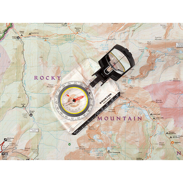 The Brunton TruArc 7 see-through compass laid on a map with the title 'Rocky Mountain' on the map around the compass.