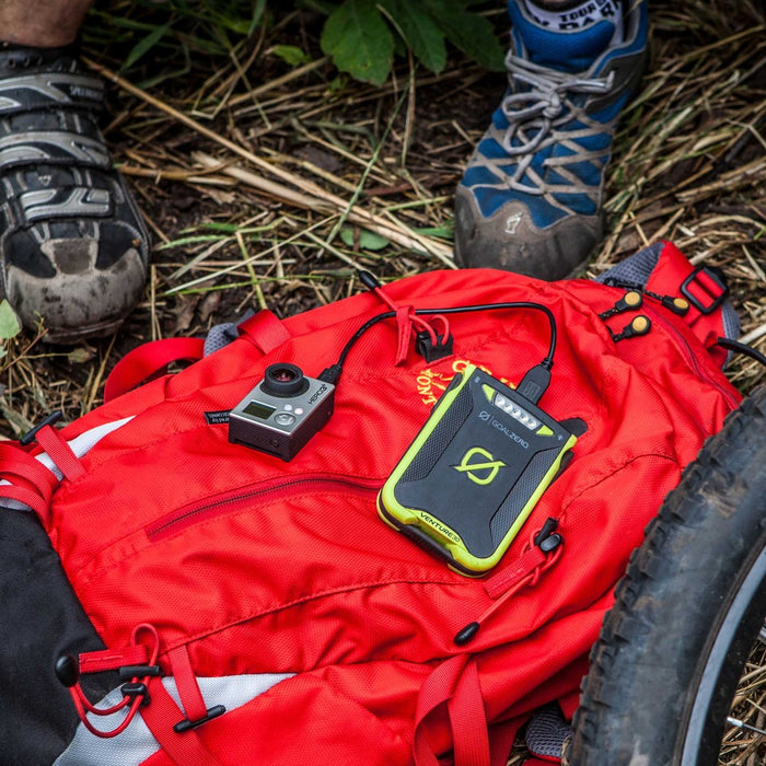 The venture 30 power bank on mountain bikers red backpack charging up a gopro camera.