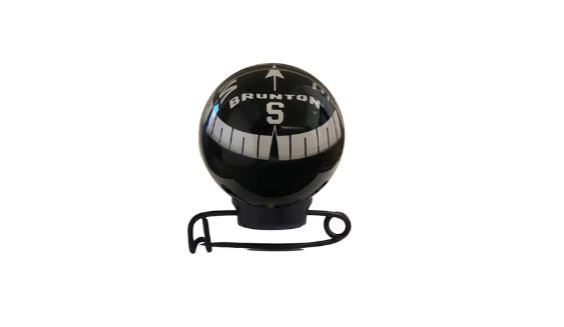 Brunton Mini Globe Compass attached on a pin in black with a reflective clear bulb. 