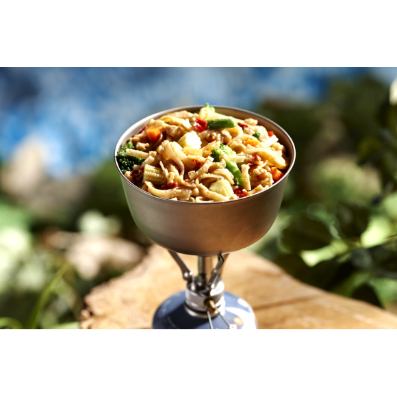 A camp stove being used to boil and cook a Freeze dried package of Happy Yak's Pad Thai.