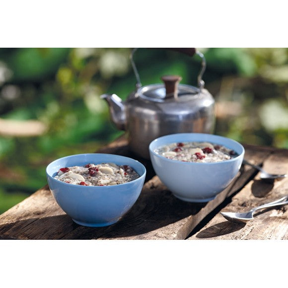 2 Pale Blue bowls of Happy Yak Chia with Almonds and Cranberry preppared Freeze Dried Food. The bowls are on a picnic table beside a kettle of hot water that was used to prepare the food.