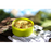 A lime green bowl of the boiled and mixed freeze dried Happy Yak Coconut Thai Soup with a napkin and camping spoon on top of a tree log.